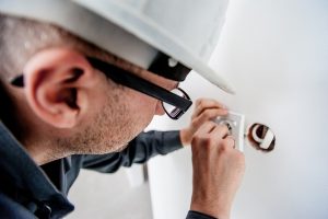 Eletricista prestando assistência residencial consertando tomada
