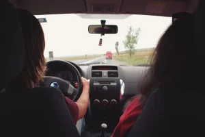 duas mulheres dirigindo na estrada