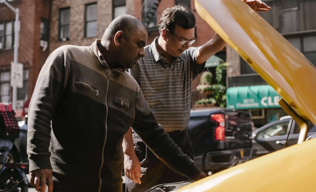 dois homens consertando um carro