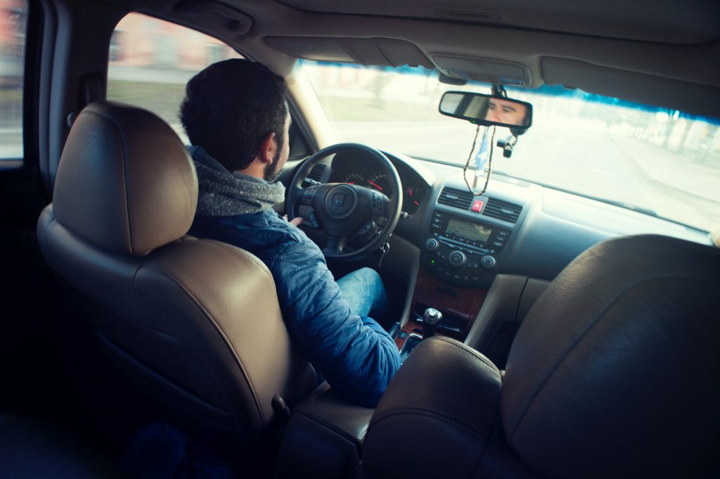 homem com casaco dentro do carro