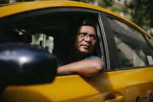 homem olhando da janela de um carro amarelo